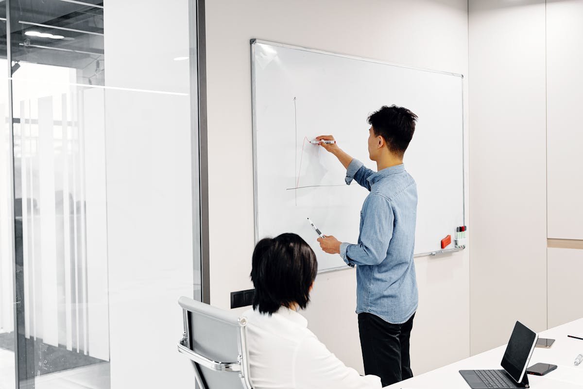 Engineer drawing system design diagram on whiteboard