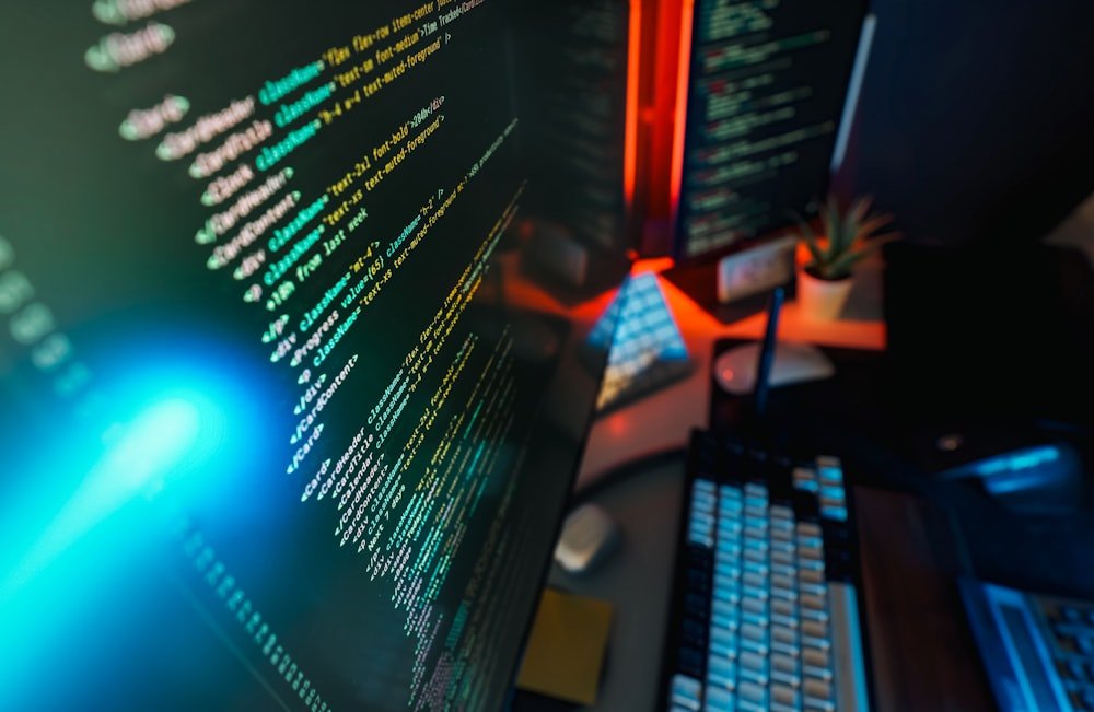 Programmer workspace with code displayed on monitors