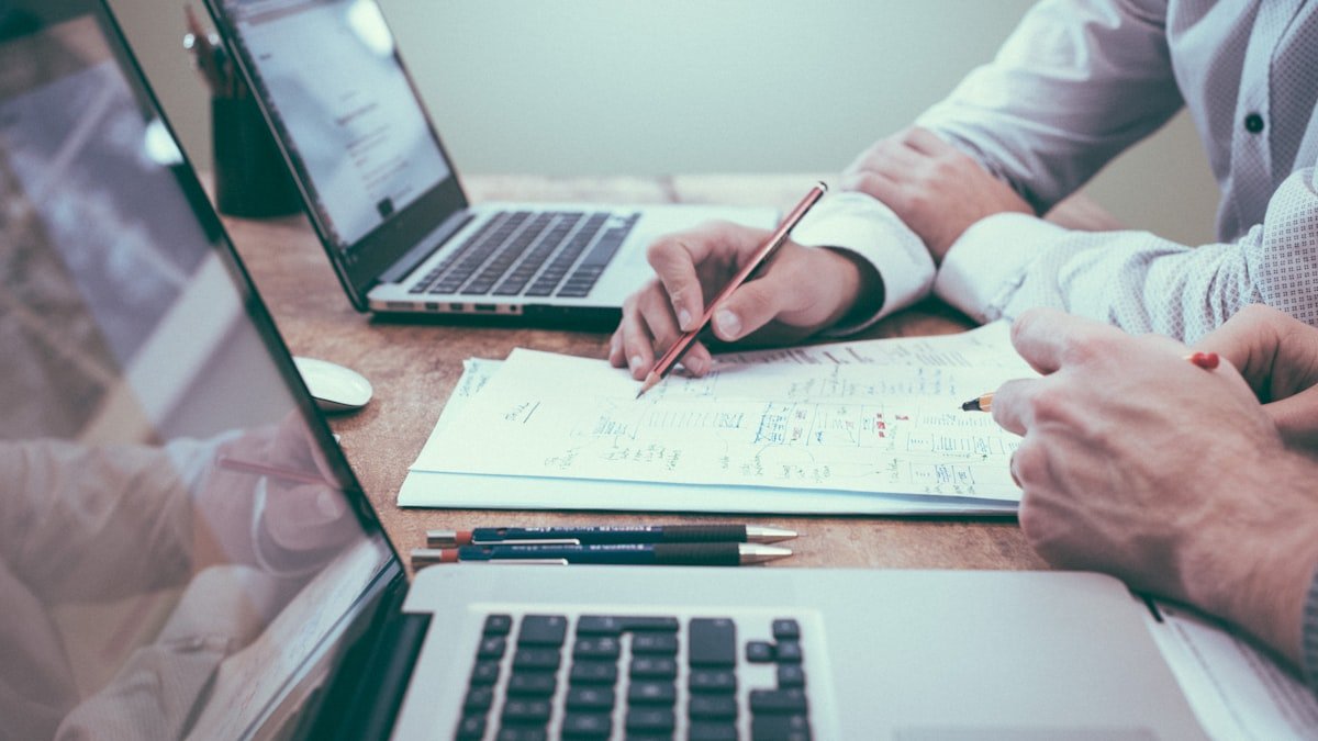 Developer researching market compensation data with laptop and notes