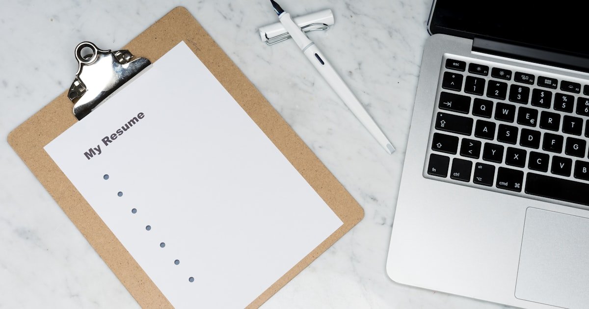 Developer reviewing a printed tech resume at a desk
