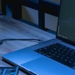 Laptop and phone on a desk with coding software open